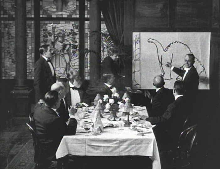 Winsor McCay sketching at a dinner party in a still from the film Gertie the Dinosaur (1914)